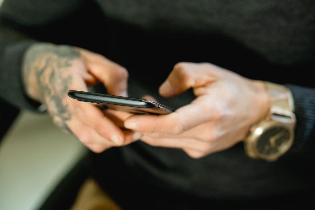 Tattooed hands holding a smartphone