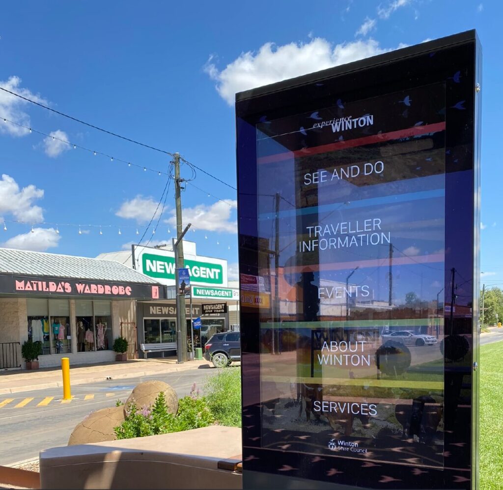 Outdoor touchscreen on Elderslie Street, Winton, showing the Experience Winton menu: See and do, Traveller information, Events, About Winton and Services